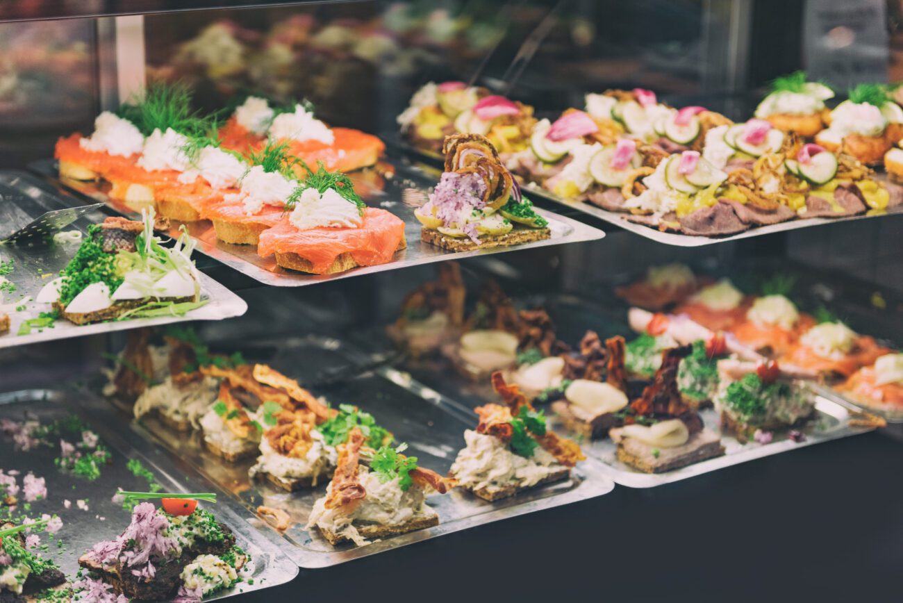 Assorted canapés and appetizers arranged on trays in a display case